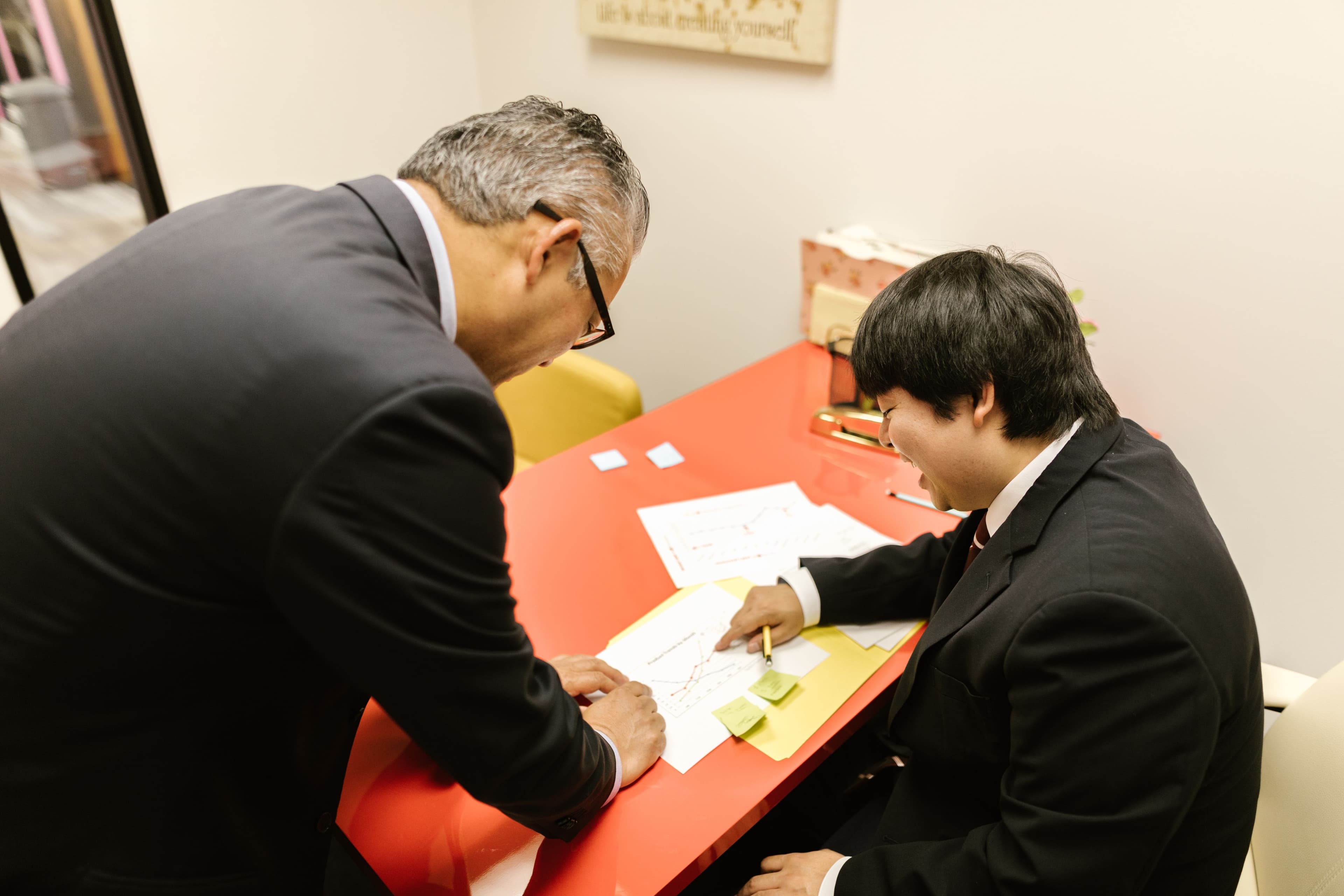 Japanese digital strategists reviewing blueprints in an Osaka meeting room